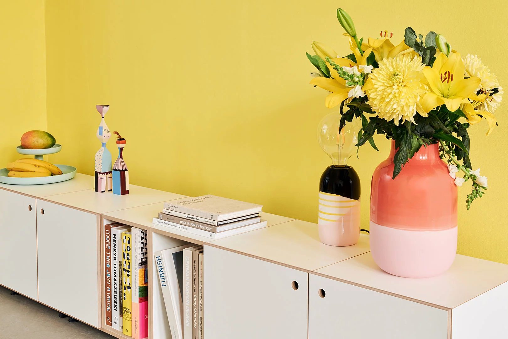 Kategorien, Lowboard, Wand, Bücher, Vase, Blumen, Obst, Lampe, gelb, pink, bunt, 3by2